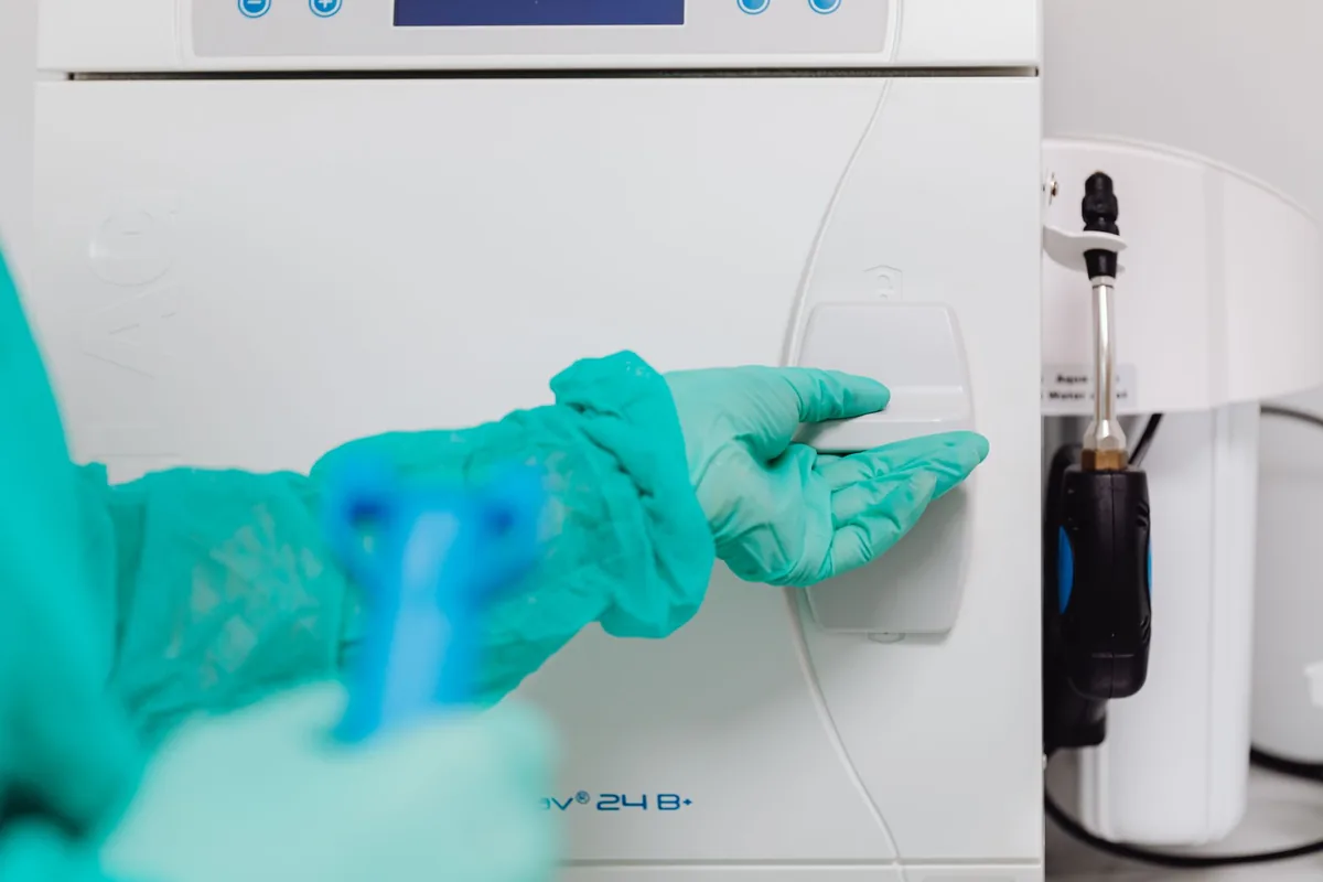 Equipo veterinario con guantes desinfectando una superficie clínica durante el aseo del box