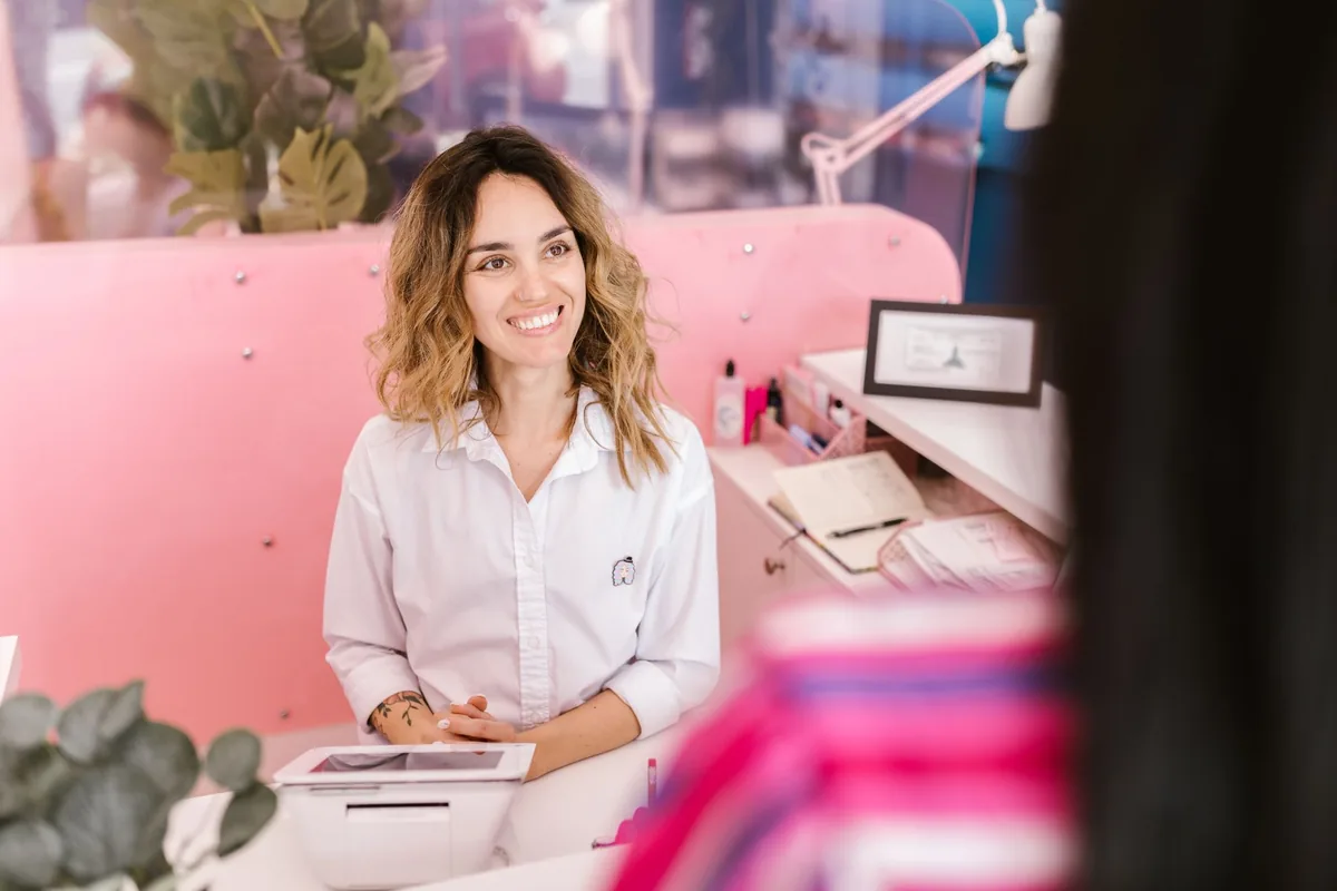 Recepcionista de una clínica veterinaria en el mesón, con tablet para gestionar la agenda