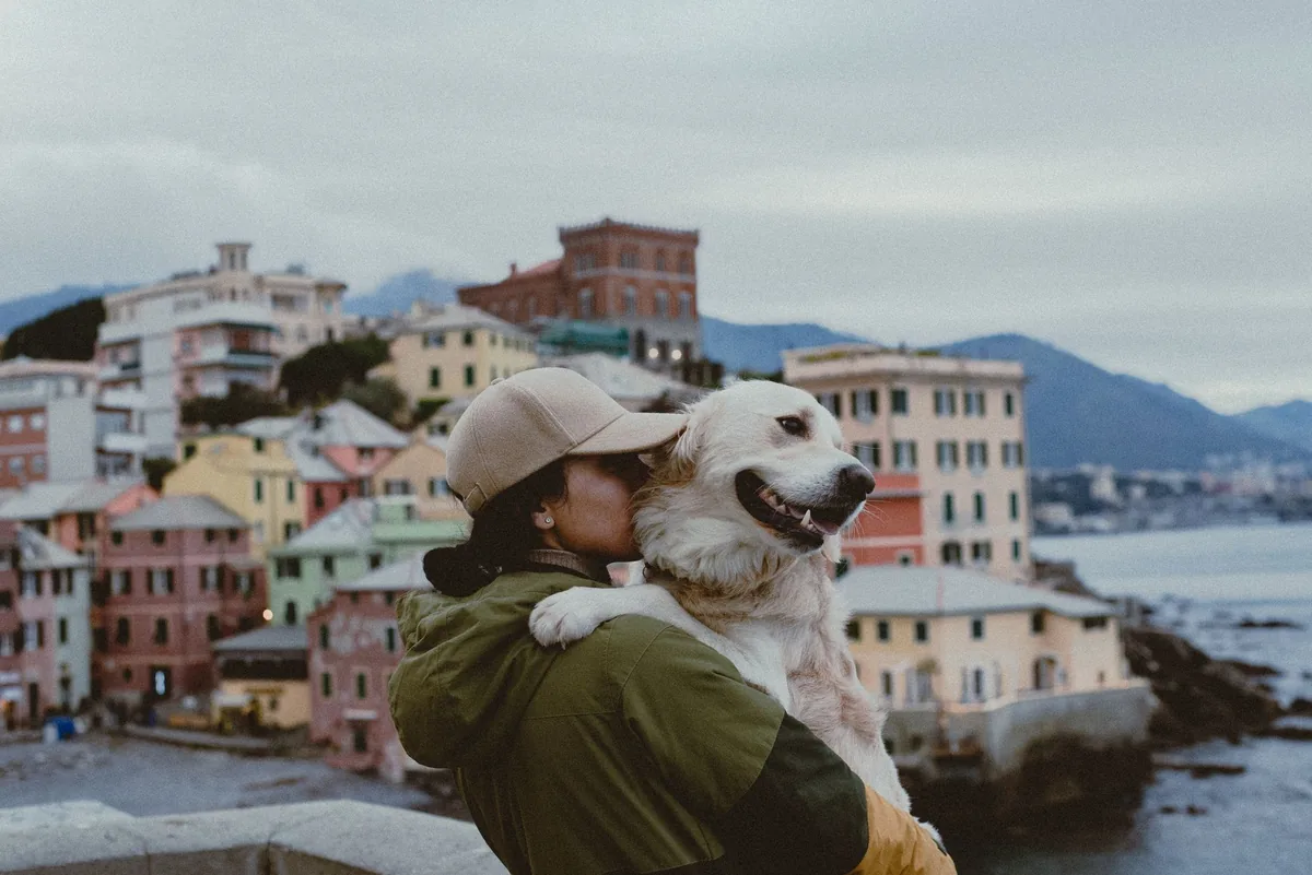 Tutora abrazando a su perro antes de dejarlo en el hotel de mascotas para irse de viaje