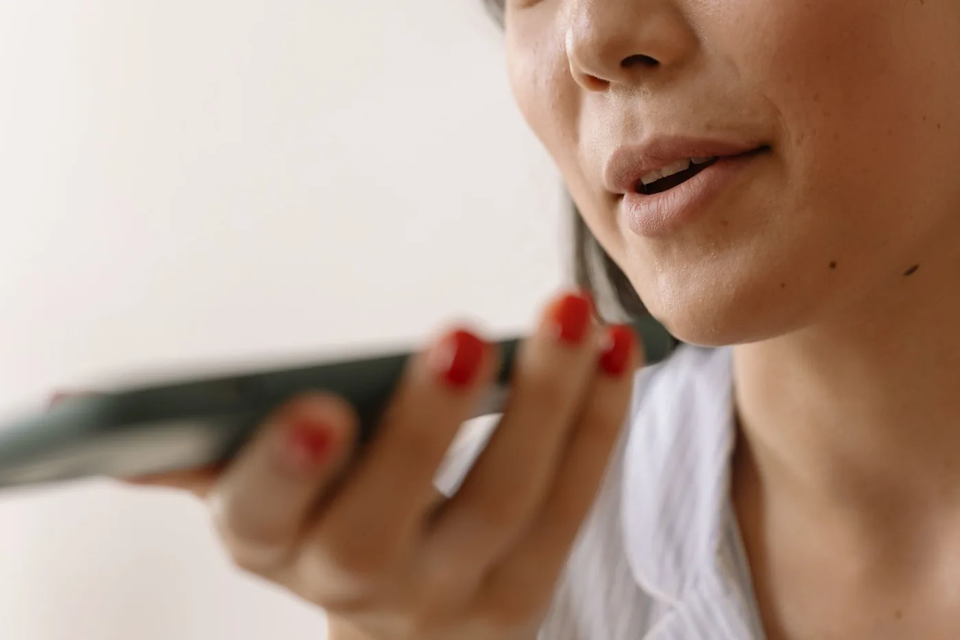 Profesional dictando la ficha clínica por voz, hablándole al celular como si enviara un mensaje de audio