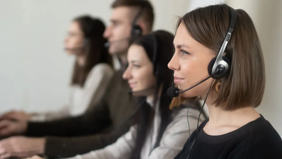 Equipo de atención a clientes con audífonos en una oficina
